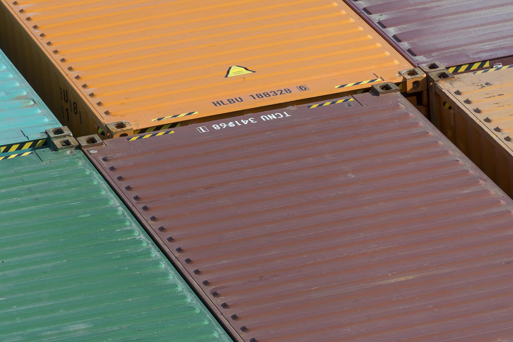 Aerial view of vibrant cargo containers arranged in a pattern, emphasizing logistics and transportation.
